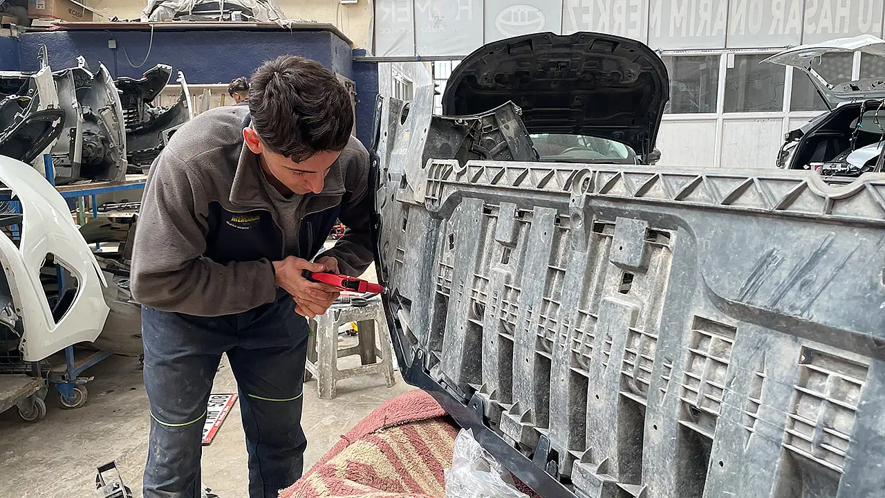 Sabahın erken saatlerinde sanayi sitesindeki dükkanına gelerek kaporta tamir işlerinde çalışan genç sporcu, iş disipliniyle ustalarının takdirini topluyor.