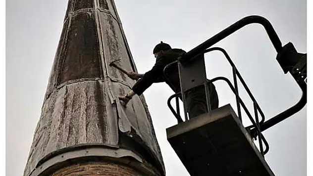 Cami minaresini vinç üzerinde tamir etti