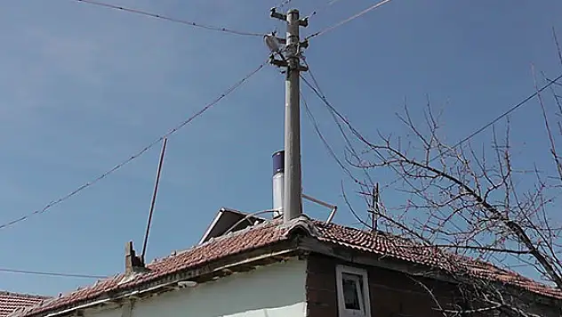 Evin ortasındaki elektrik direği görenleri şaşırtıyor