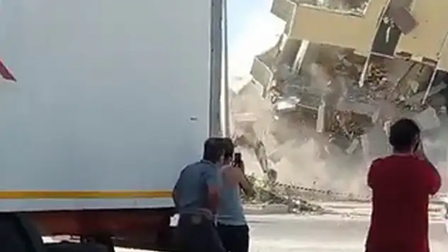 Hatay'da ağır hasarlı bina yıkım sırasında yola devrildi
