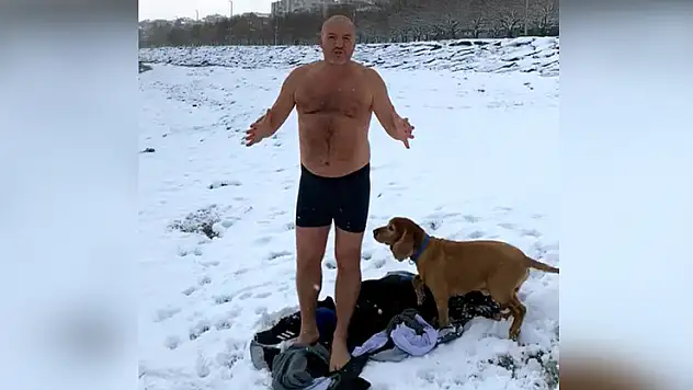 Karlı havaya aldırış etmeden köpeğiyle beraber denizde yüzdü