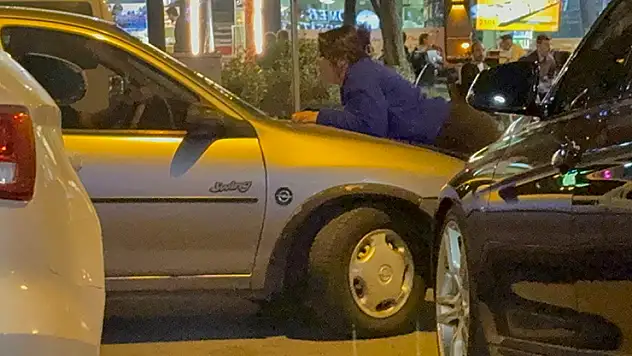 Kocasını engellemek için otomobilin kaputuna yattı