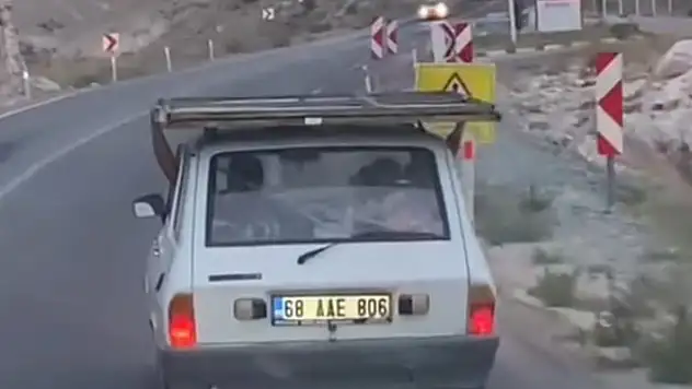 Otomobilin üstündeki demir kapıyla tehlikeli yolculuk
