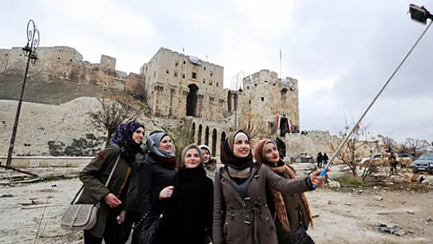 Şam'dan Halep'e gelen turistler yıkıntılar arasında poz verdi