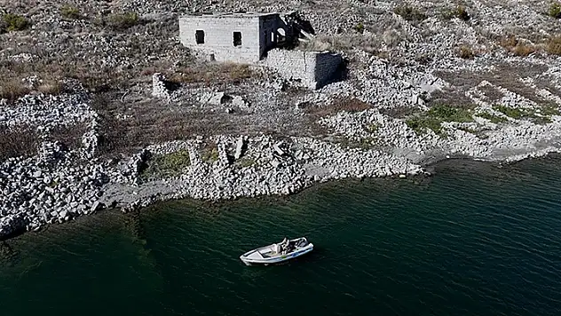 Su altında kalan mahallesinin üzerinde balık avlıyor